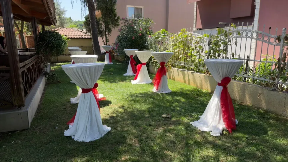 Kırmızı fiyonklu kokteyl masası kiralama açık alan kurulumu
