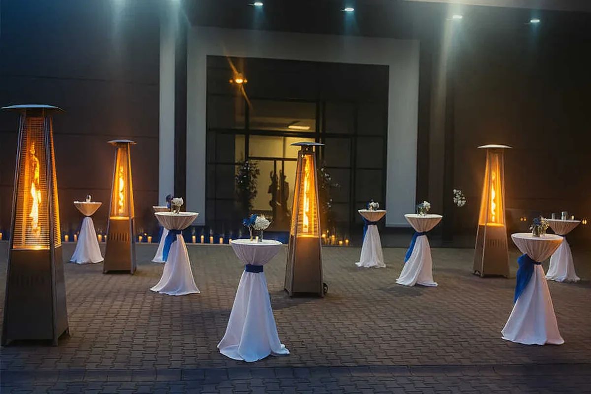 Gece kokteyl alanında yanan piramit ısıtıcılar ve bistro masaları